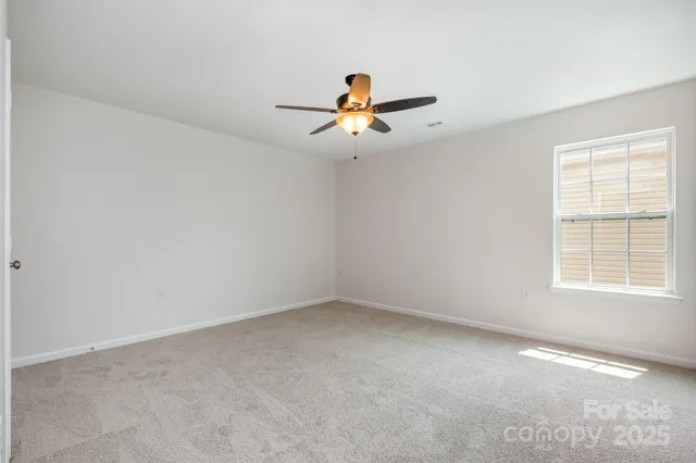 an empty room with chandelier fan