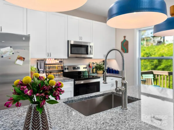 a kitchen with stainless steel appliances granite countertop a stove a sink and a microwave