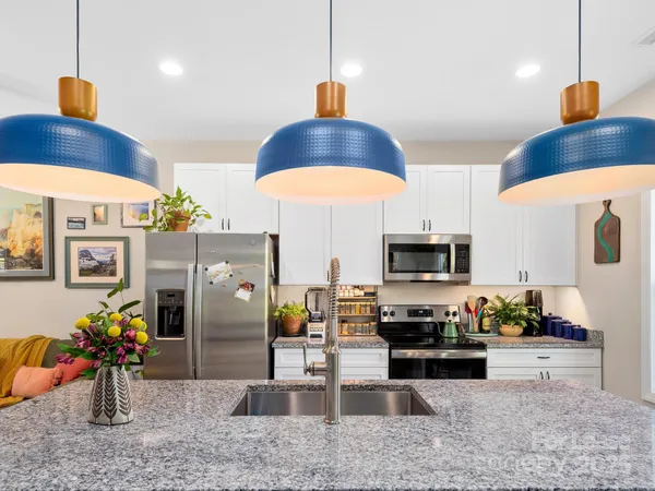 a kitchen with stainless steel appliances granite countertop a sink a stove and a wooden floors