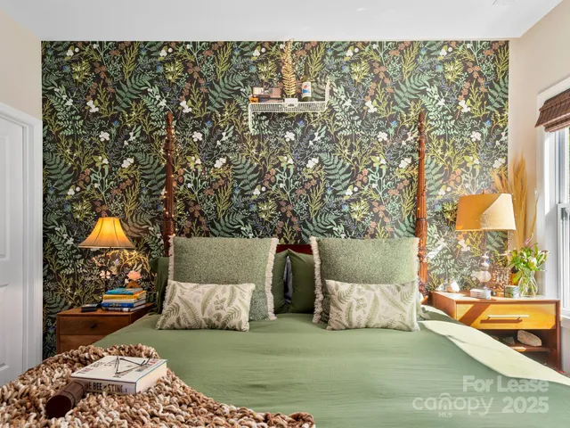 a bed sitting in a bedroom next to a window with a large window