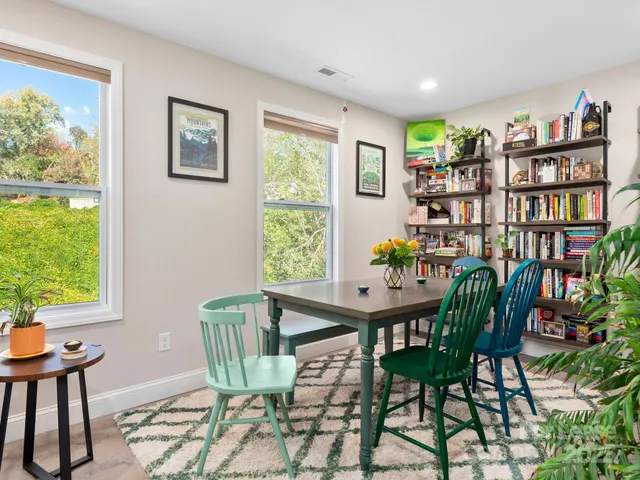 a view of a workspace with furniture and a window