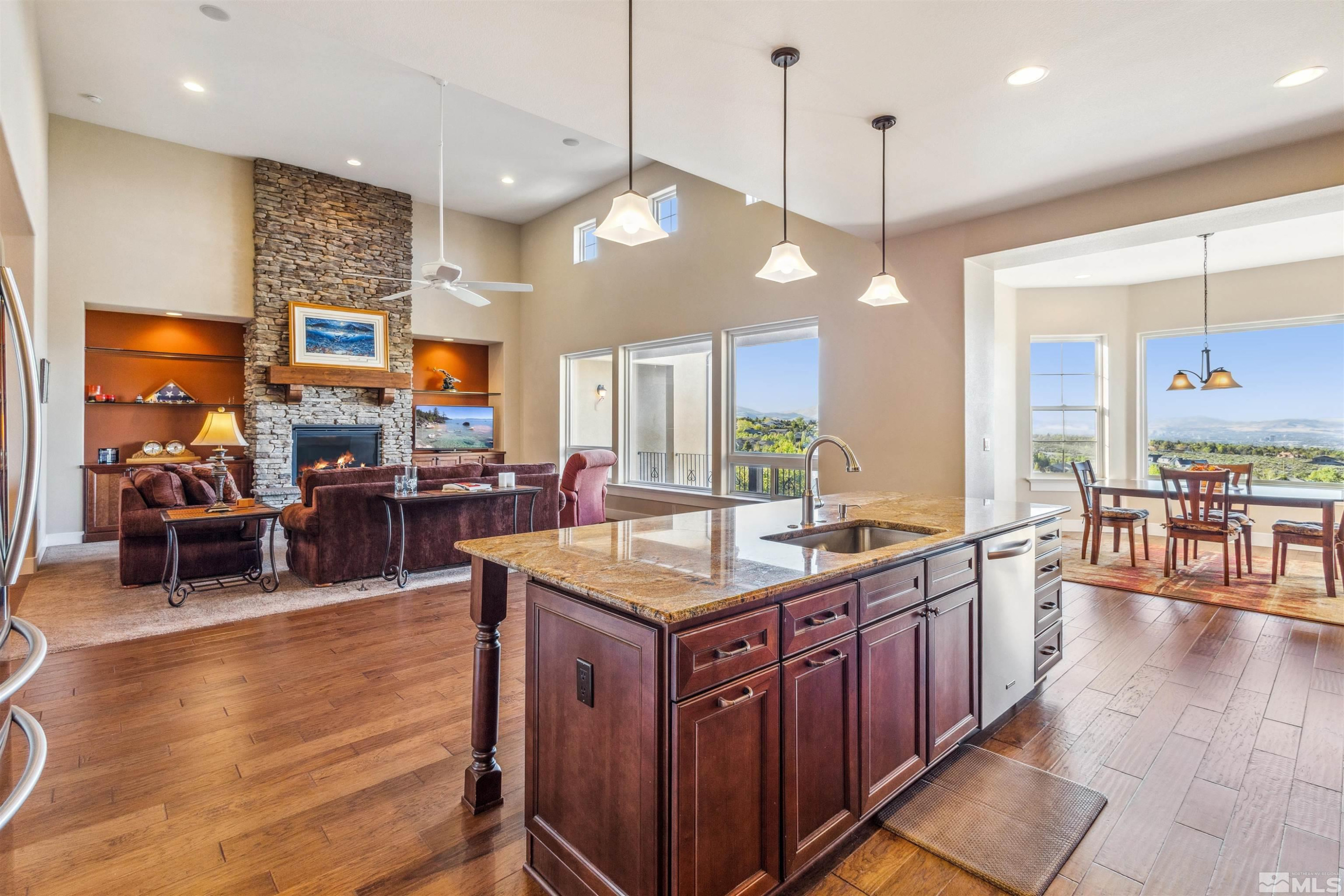 3705 Boulder Patch Reno, NV 89511 - Photo 16 of 41 a kitchen with stainless steel appliances granite countertop a stove top oven a refrigerator a sink and a dining table with the living room view