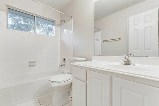 a bathroom with a granite countertop sink a toilet and a bathtub