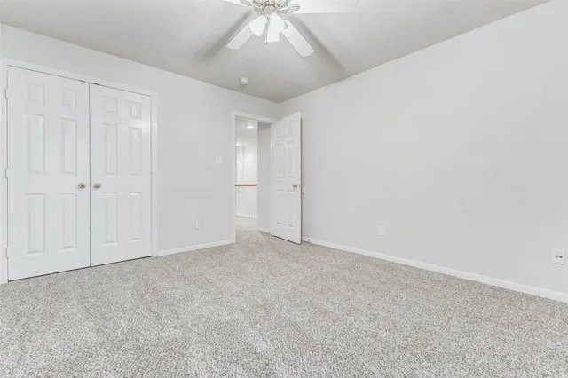 an empty room with a chandelier fan