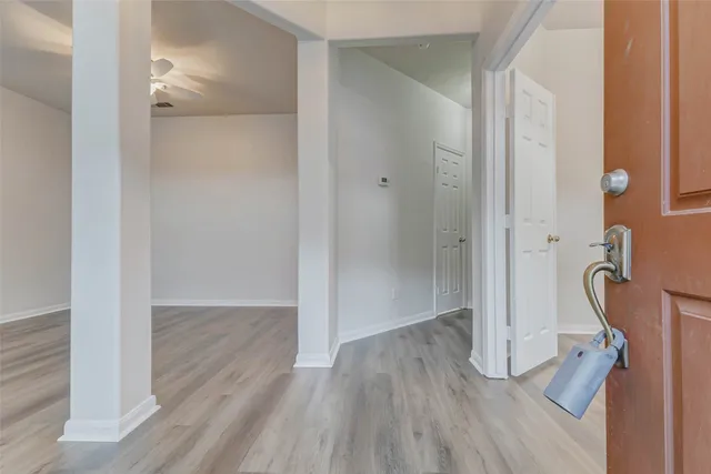 a view of a hallway with wooden floor