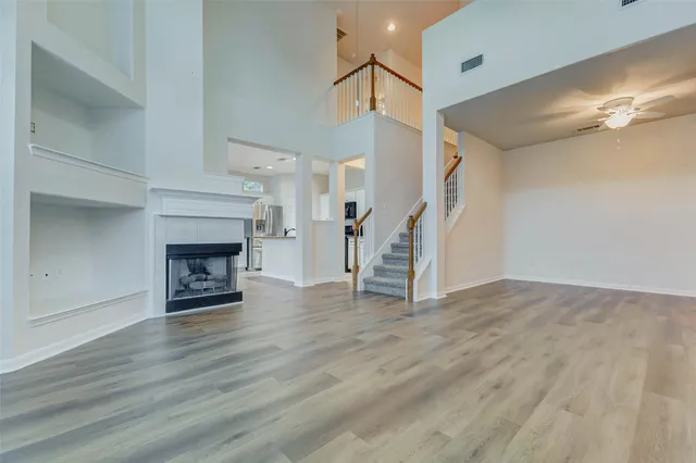 a view of empty room with wooden floor and fireplace