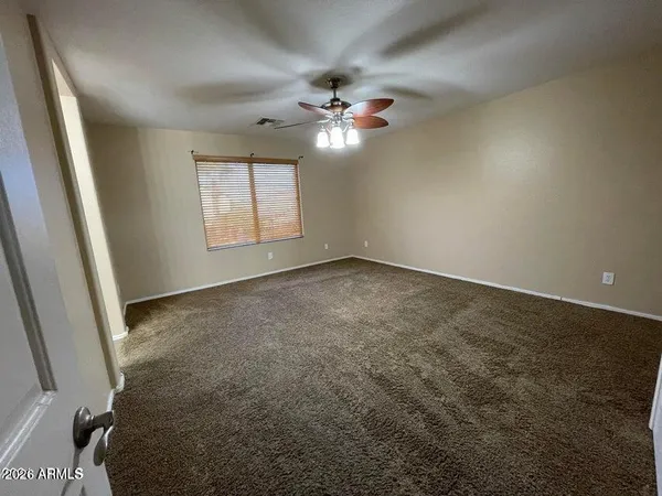 an empty room with a ceiling fan and a window