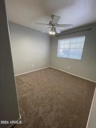 en empty room with windows and ceiling fan