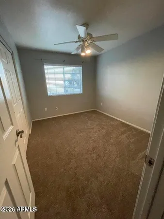 an empty room with windows and fan