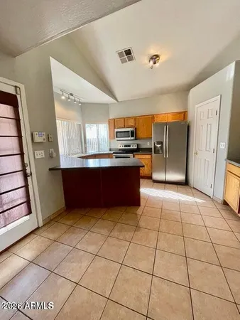 a kitchen with stainless steel appliances granite countertop a refrigerator and a stove top oven