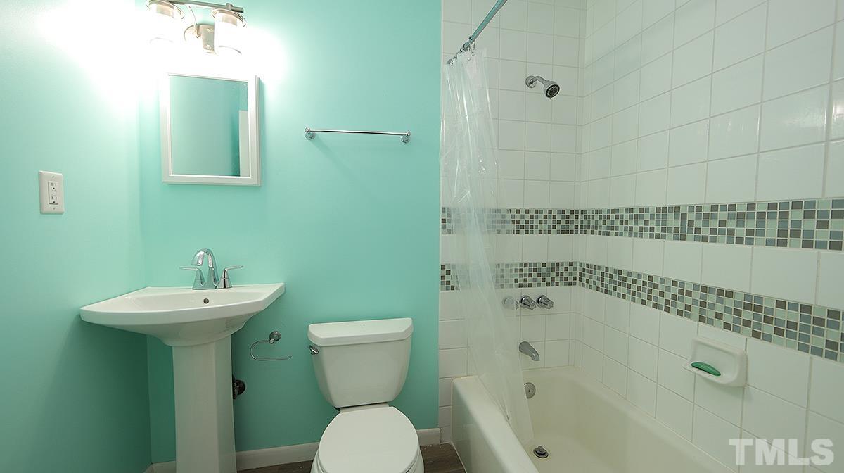 617 Locust Lane Raleigh, NC 27603 - Photo 10 of 15 a bathroom with a sink a toilet and shower