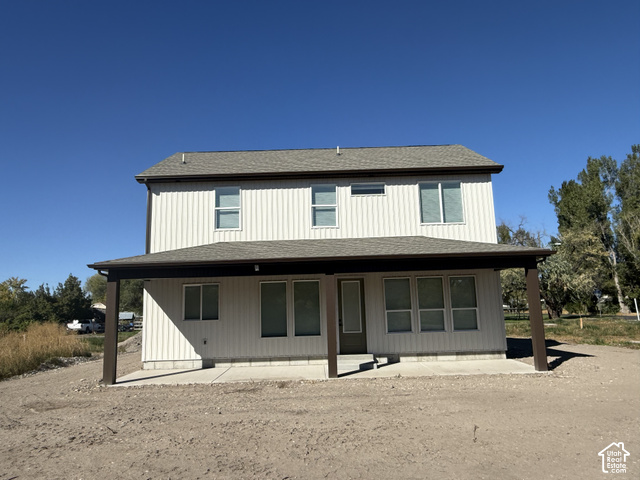 658 West 500 South, Unit 2 Logan, UT 84321 - Photo 18 of 18 Two-story exterior with vertical siding, covered patio, dark roof, and multiple windows