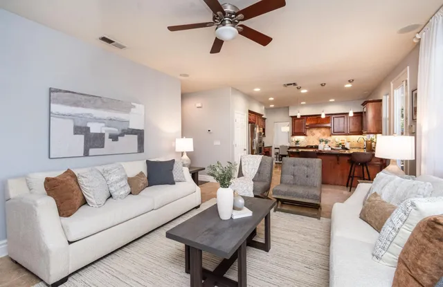 a kitchen with stainless steel appliances granite countertop a stove refrigerator a sink dishwasher a dining table and chairs with wooden floor