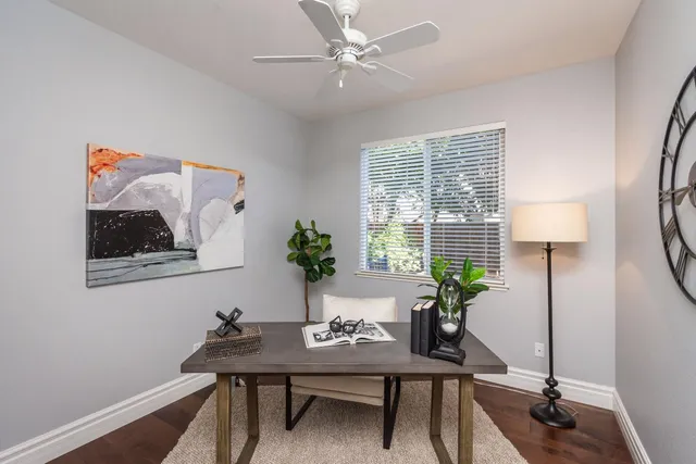 a view of a workspace room with wooden floor and dining table