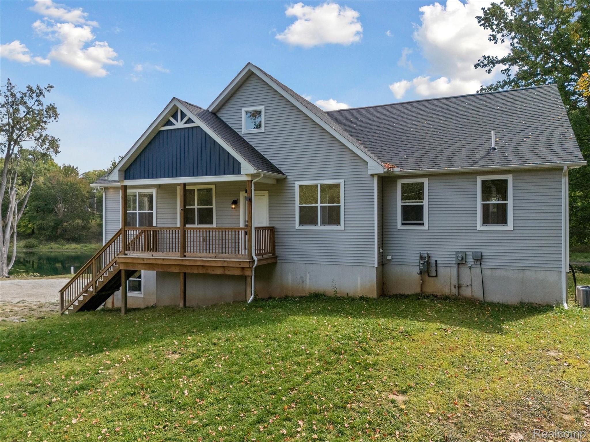 441 West Dryden Road Metamora, MI 48455 - Photo 52 of 62 Back of property with covered porch, a shingled roof, a lawn, and stairs