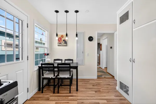 a kitchen with a table chairs stainless steel appliances and cabinets