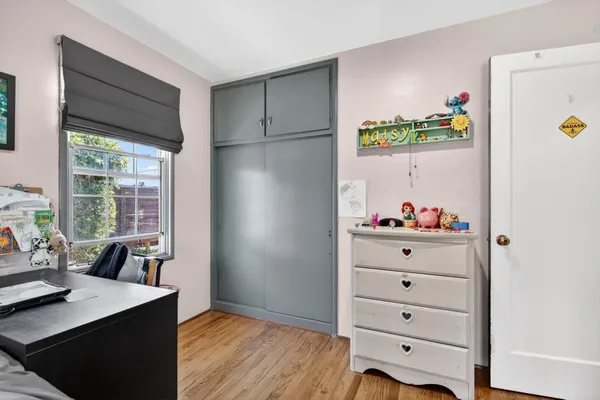 a bedroom with a bed and wooden floor