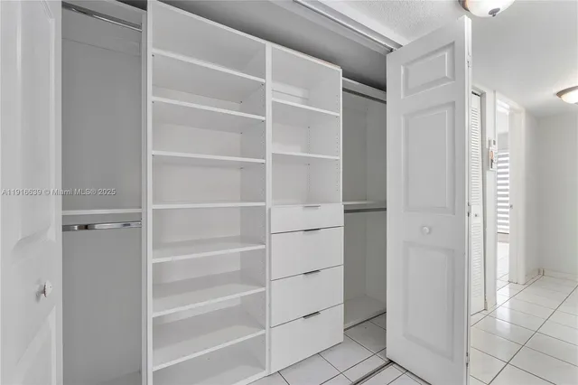 a view of walk in closet with empty racks