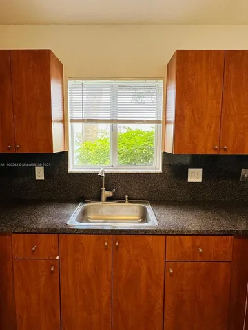 a kitchen with granite countertop cabinets and window