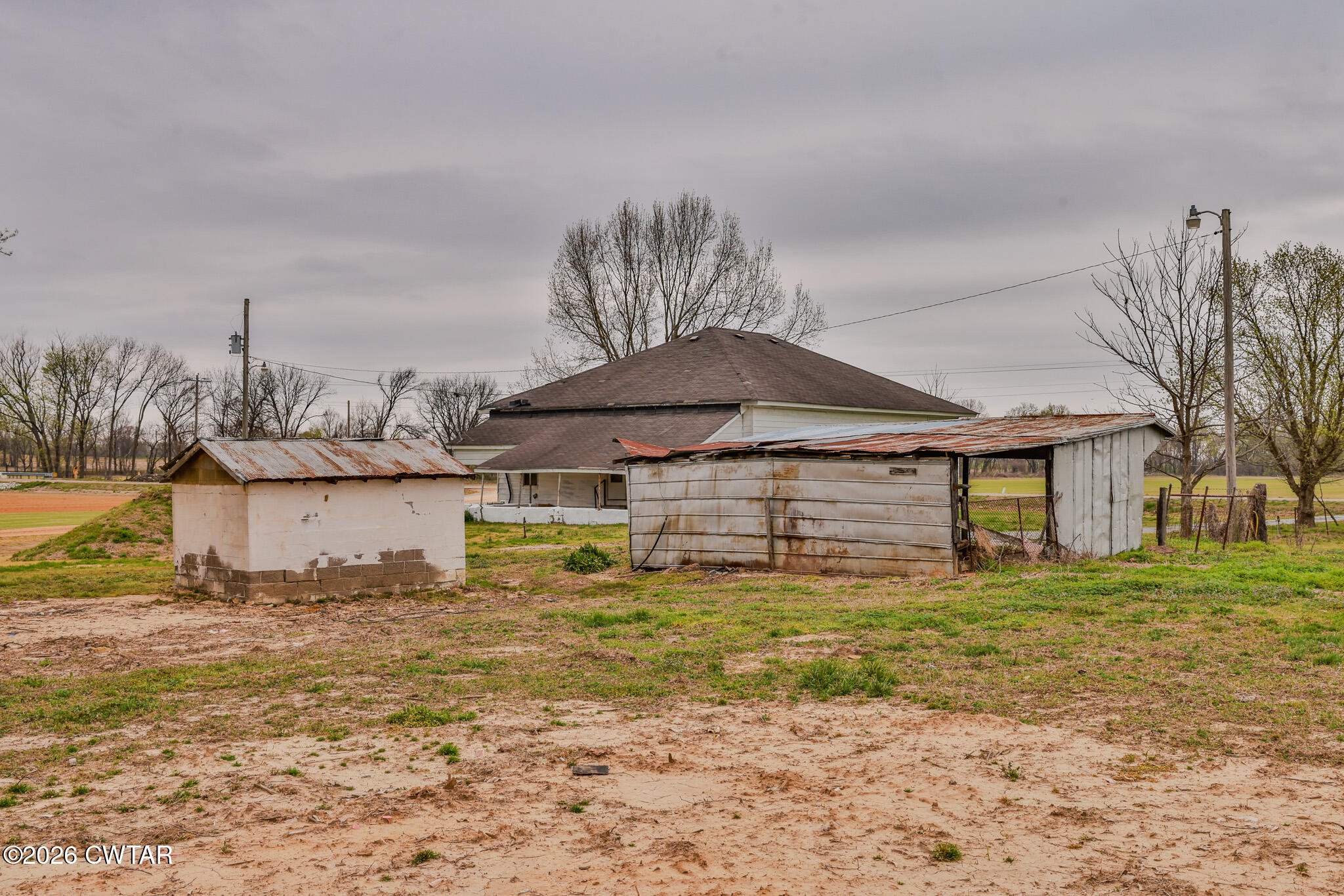 76 New Bethlehem Road Dyer, TN 38330 - Photo 15 of 39 a yellow house covered with tall trees