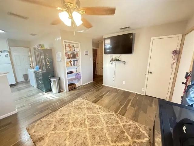 a view of a livingroom with wooden floor and a flat screen tv