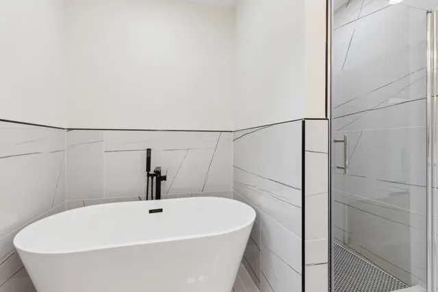 a white bath tub with shower