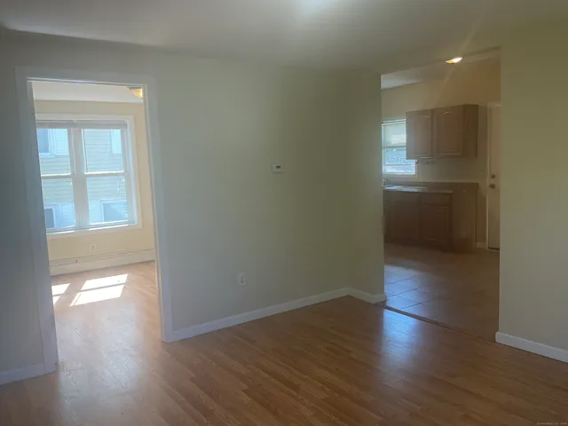 a view of a small space with wooden floor and a window