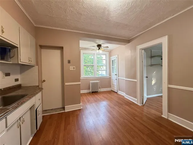 a view of a kitchen with wooden floor and electronic appliances