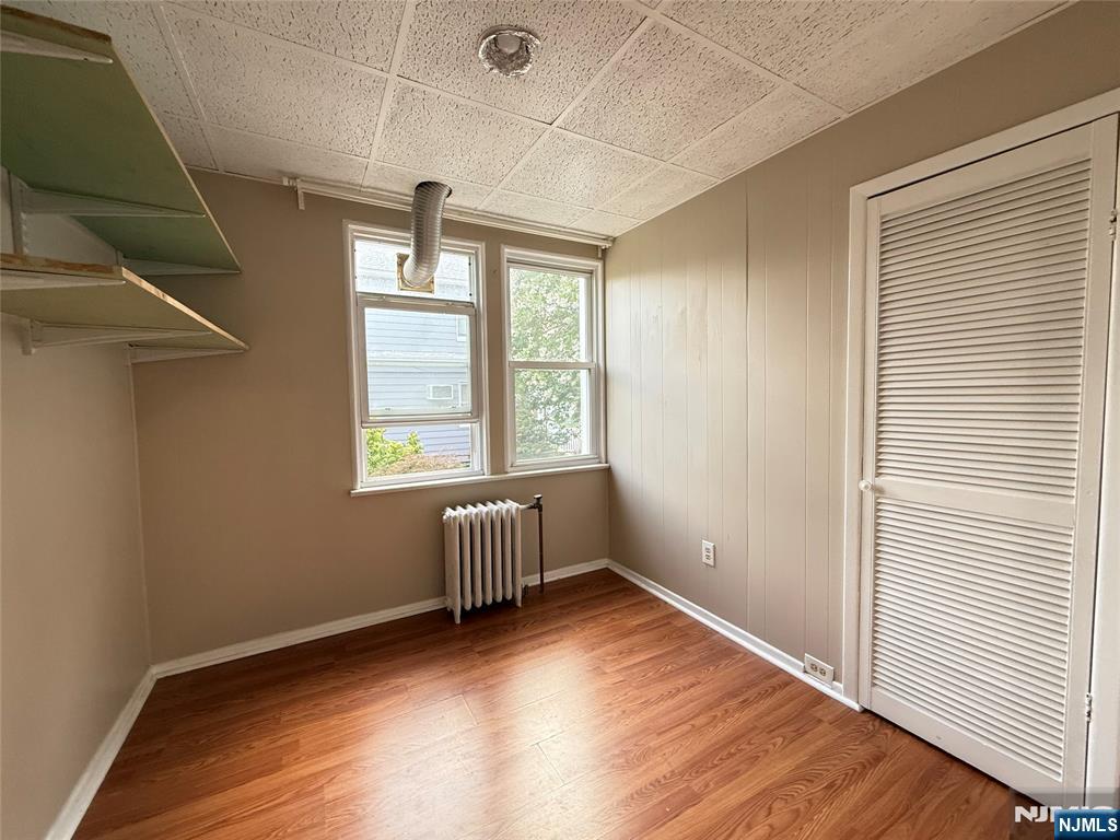 84 9th Street, Unit 1 Wood-Ridge, NJ 07075 - Photo 15 of 22 an empty room with wooden floor and windows