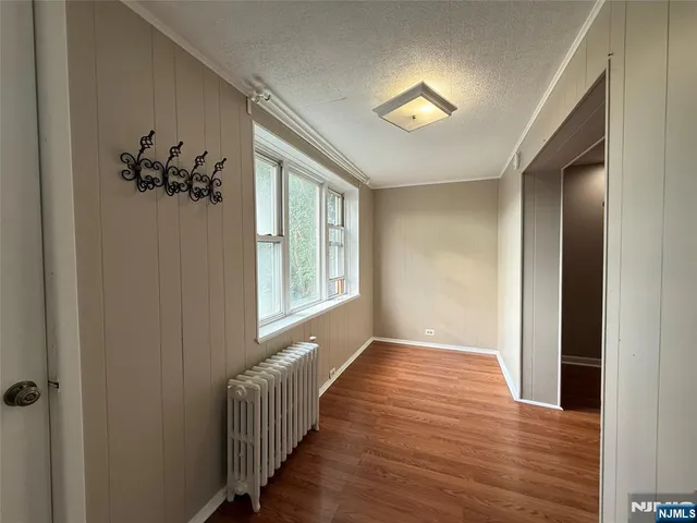 a view of a hallway to a bedroom with wooden floor and a chandelier