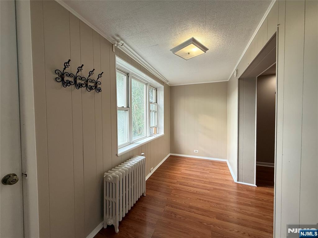 84 9th Street, Unit 1 Wood-Ridge, NJ 07075 - Photo 19 of 22 a view of a hallway to a bedroom with wooden floor and a chandelier