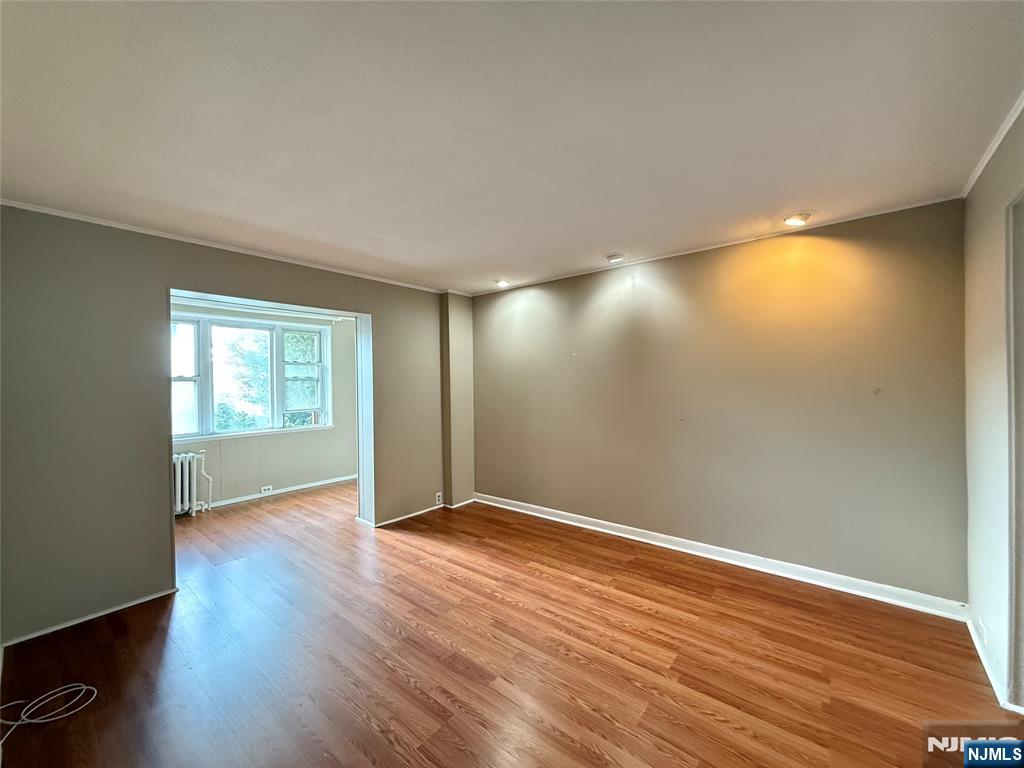 84 9th Street, Unit 1 Wood-Ridge, NJ 07075 - Photo 3 of 22 a view of an empty room with wooden floor and a window