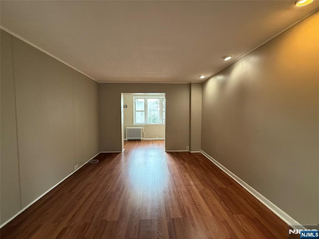 84 9th Street, Unit 1 Wood-Ridge, NJ 07075 - Photo 6 of 22 an empty room with wooden floor and windows