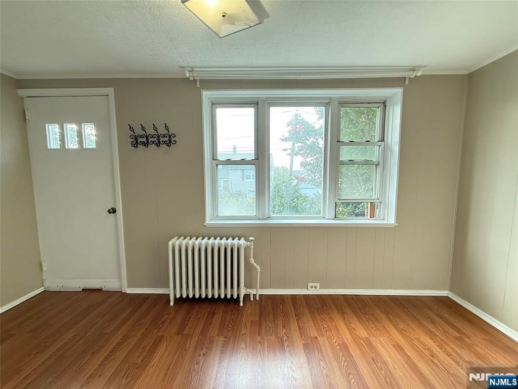 84 9th Street, Unit 1 Wood-Ridge, NJ 07075 - Photo 8 of 22 an empty room with wooden floor and windows