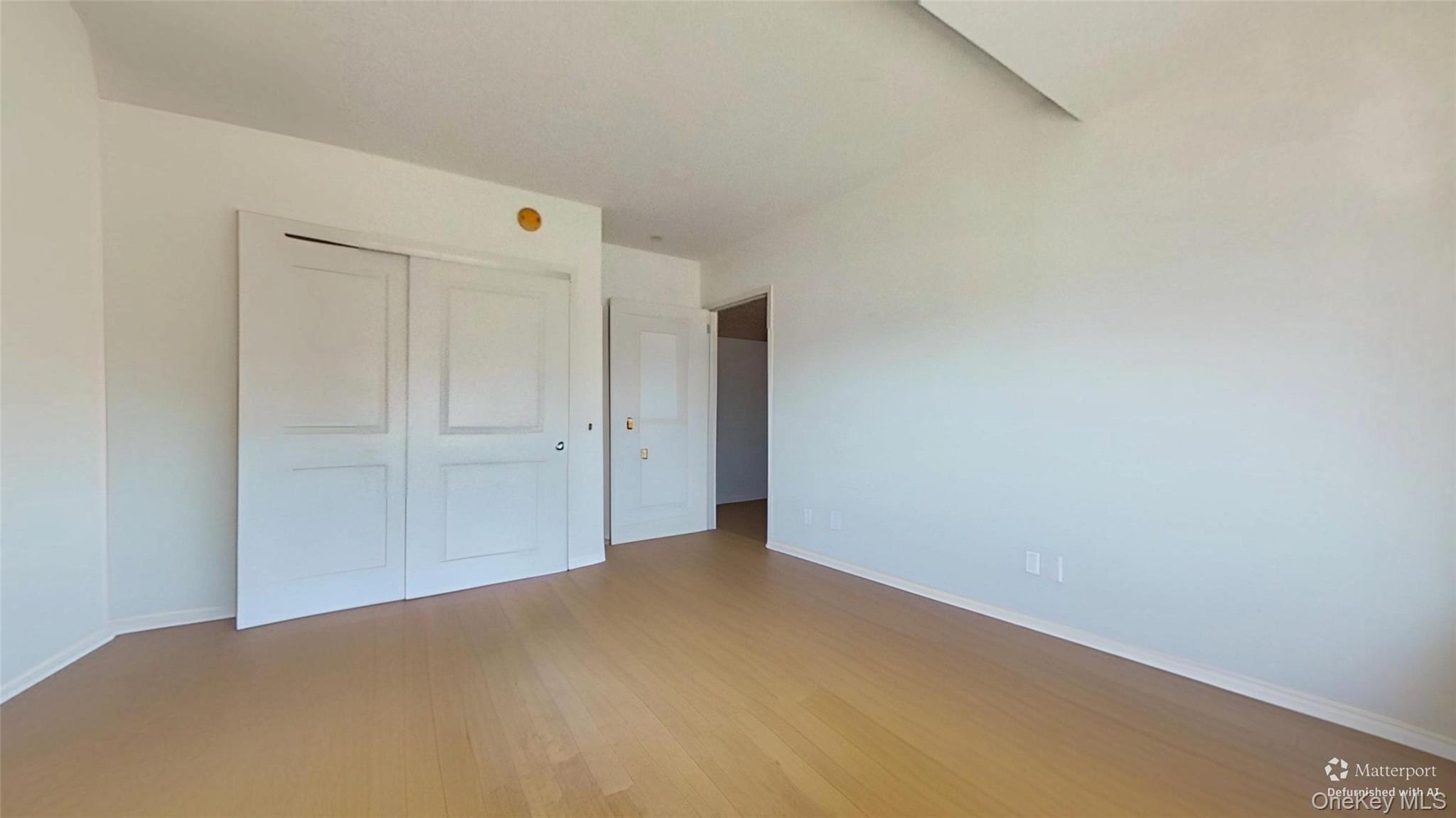 116-12 Ocean Promenade, Unit 210 Queens, NY 11694 - Photo 13 of 28 Unfurnished bedroom featuring light wood-style floors and a closet