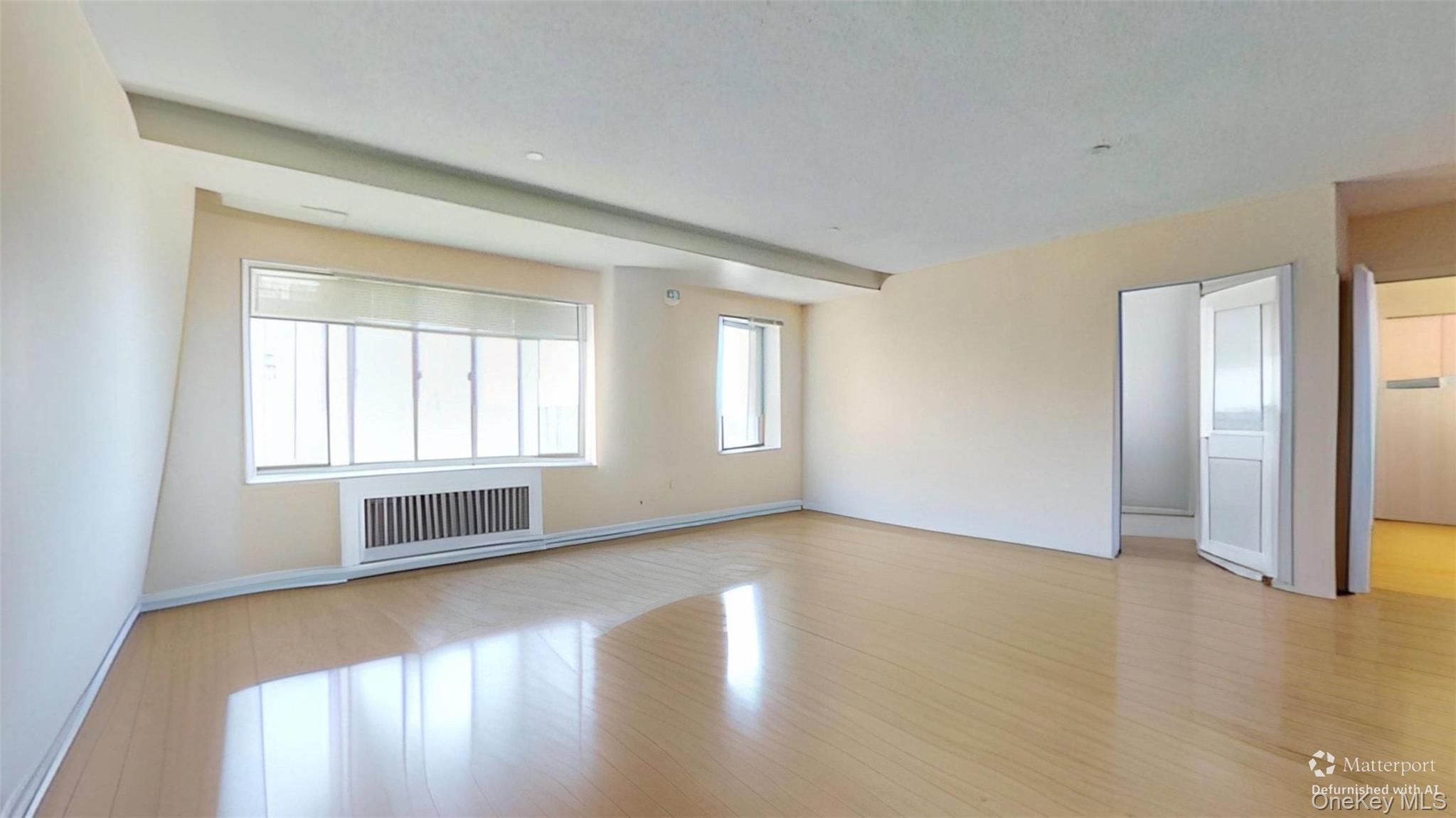 116-12 Ocean Promenade, Unit 210 Queens, NY 11694 - Photo 5 of 28 Unfurnished living room featuring plenty of natural light, radiator, and light wood finished floors