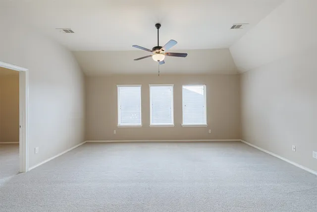 an empty room with a window and a ceiling fan