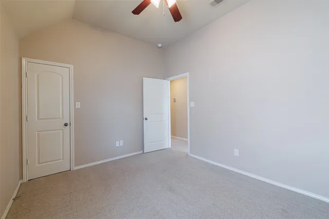 an empty room with closet and a chandelier fan