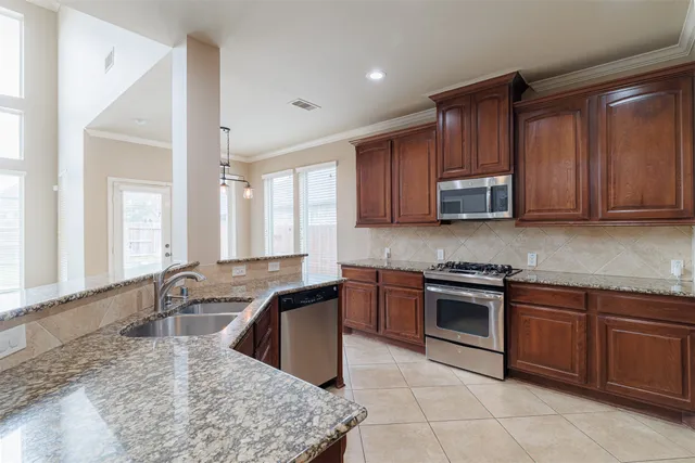 a kitchen with stainless steel appliances granite countertop a sink stove and microwave
