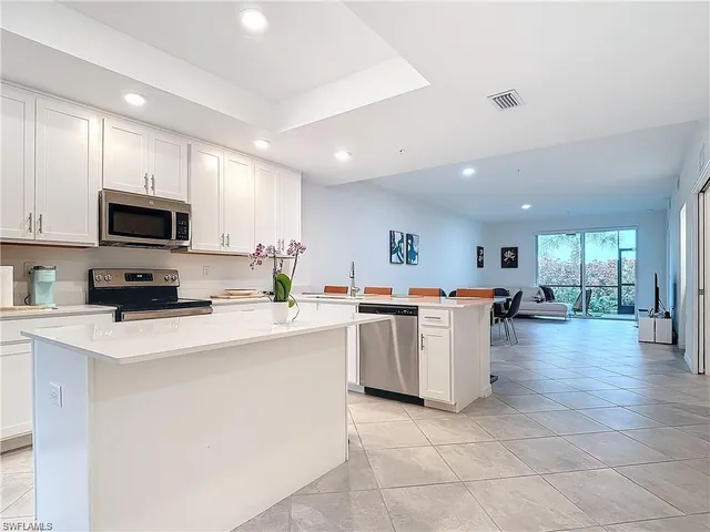 a kitchen with a sink a counter top space appliances and cabinets