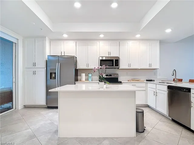 a kitchen with a refrigerator a stove top oven and white cabinets