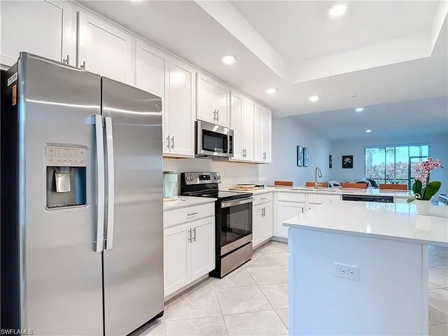 a kitchen with stainless steel appliances a refrigerator sink and microwave