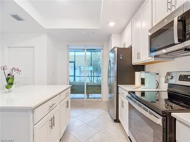 a kitchen with stainless steel appliances a stove microwave and refrigerator