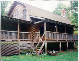 a view of a house with a small deck and a garden