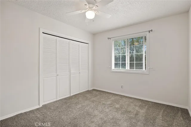 an empty room with a ceiling fan and a window