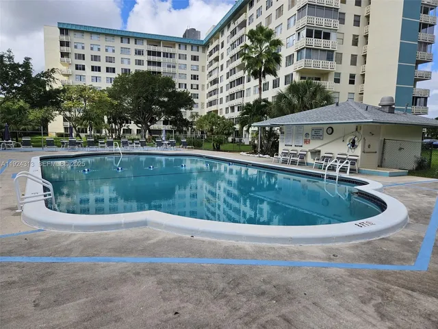 a view of swimming pool with outdoor seating and house in the background