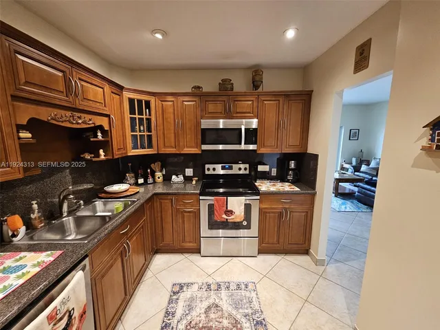 a kitchen with stainless steel appliances granite countertop a stove sink and cabinets