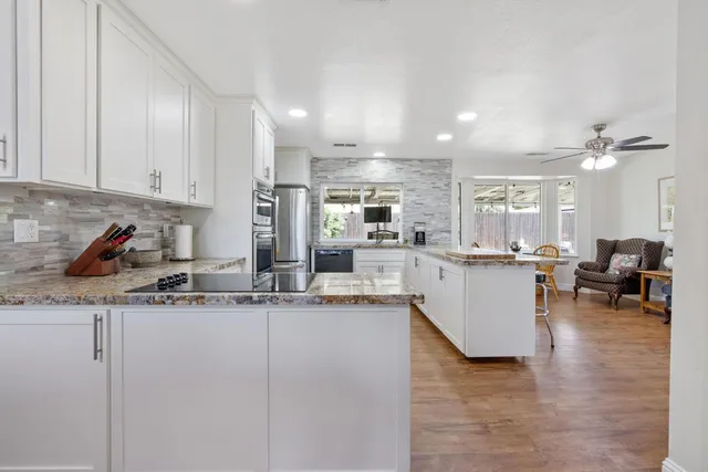 a kitchen with stainless steel appliances granite countertop a sink and cabinets