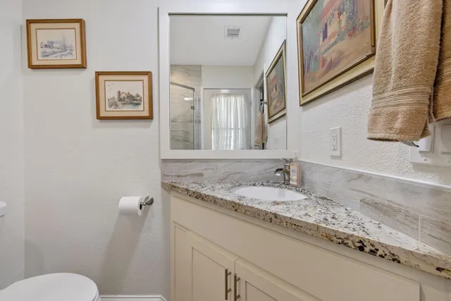a bathroom with a granite countertop sink and a mirror