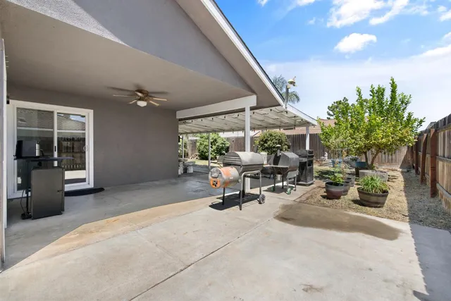 a view of a patio with a table and chairs under an umbrella